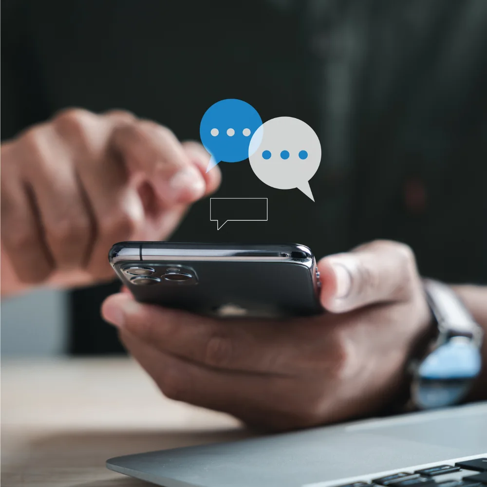 スマートフォンを両手で持ち、SNSの通知を見ている様子